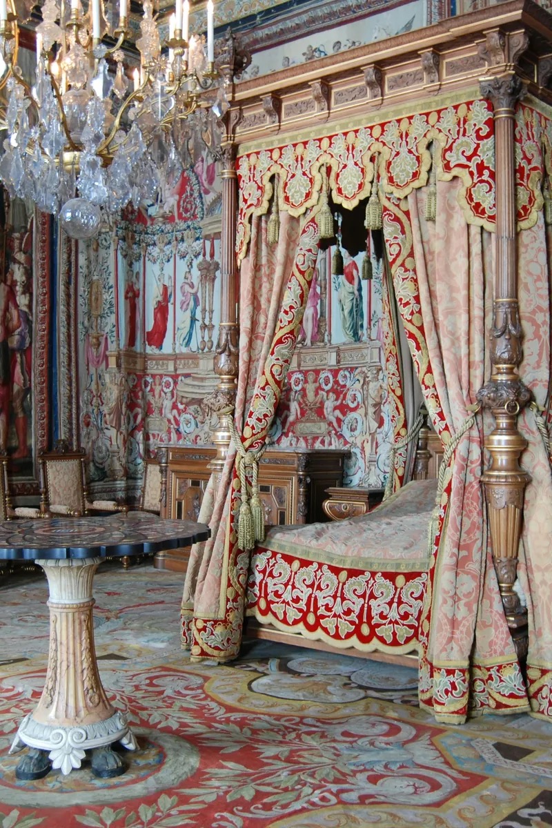 Das Château de Fontainebleau im warmen Nachmittagslicht – die geschwungene doppelte Hufeisentreppe, die sich über den weiten Cour des Adieux erhebt, mit der langen Fassade und den steilen Schieferdächern dahinter. Fontainebleau, Frankreich.